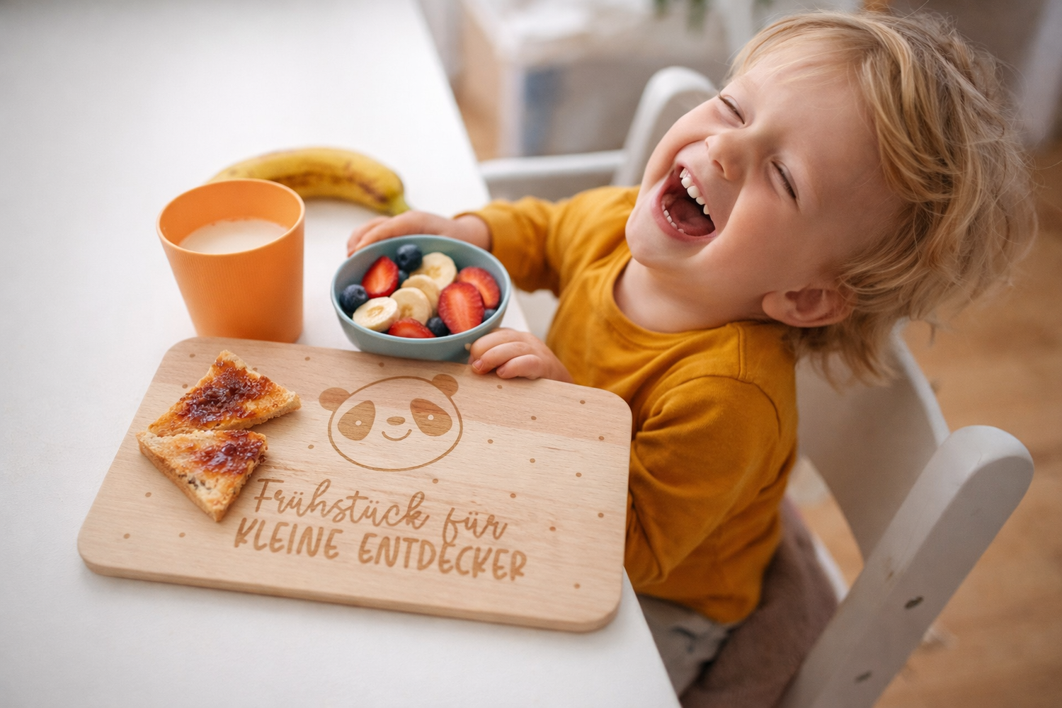 Holz Frühstücksbrettchen für Kinder mit Panda Gravur im Einsatz beim Frühstück – lachendes Kind genießt entspannt gesunde Mahlzeit
