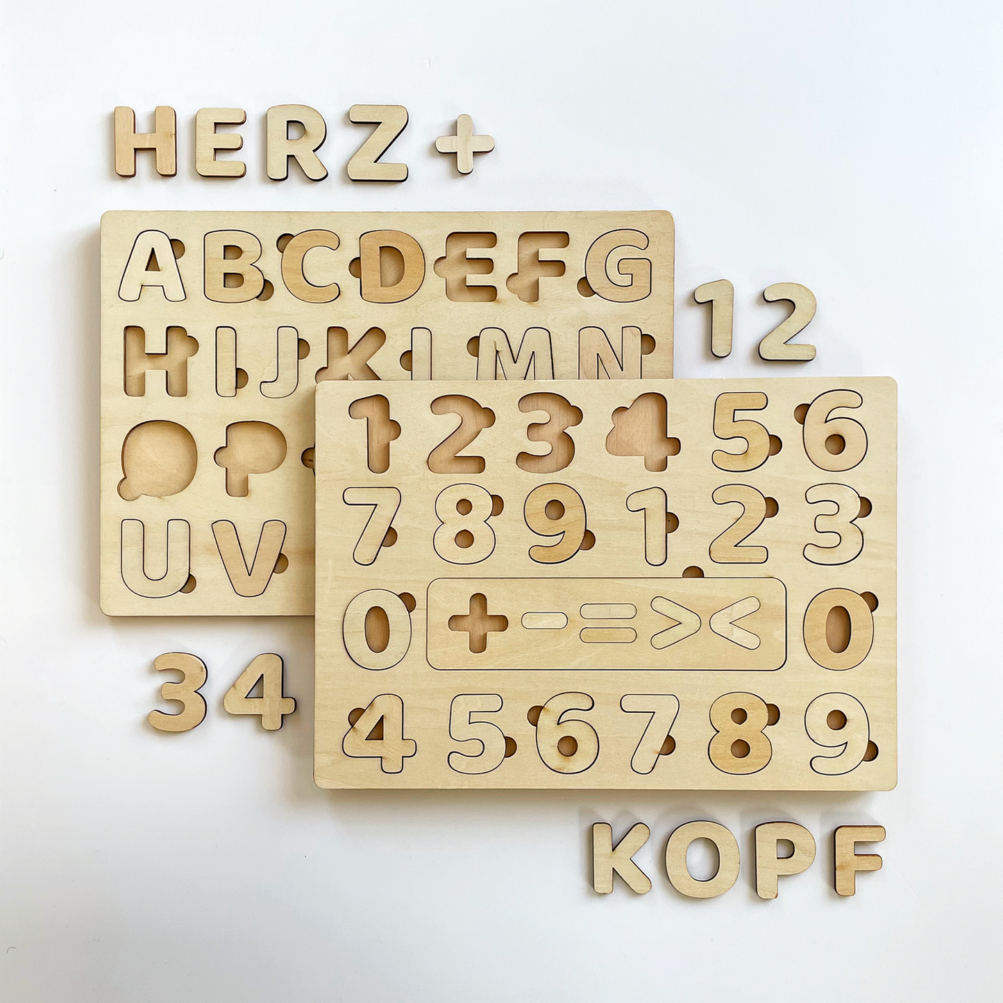 Holztafeln mit herausnehmbaren Buchstaben und Zahlen auf hellem Hintergrund.