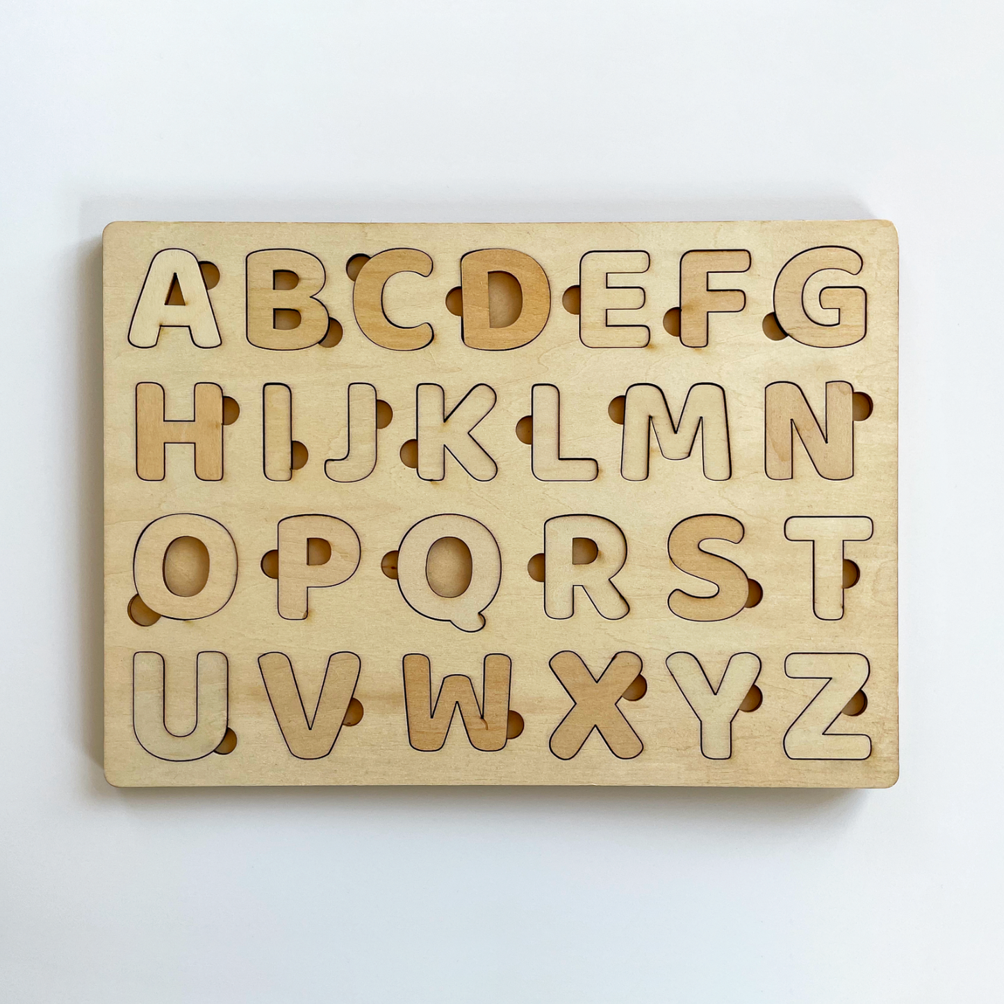 Eine Holztafel mit herausnehmbaren Buchstaben auf hellem Hintergrund.